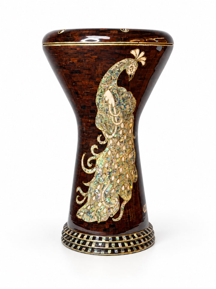 Sala Amber Peacock Sombaty darbuka stående oppreist, og viser et blekt påfuglmotiv på en mørk ravbrun mosaikkbakgrunn.