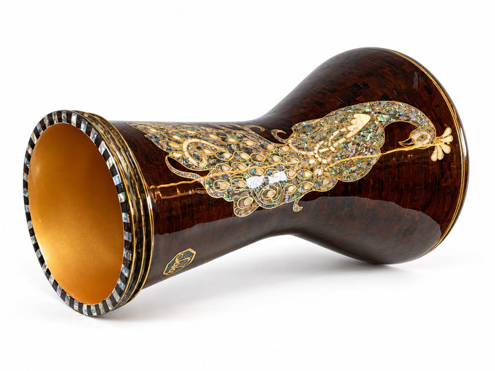 Sala Amber Peacock Sombaty darbuka på siden, som viser den åpne basen og et blekt påfuglmotiv på en mørk ravbrun mosaikkbakgrunn.