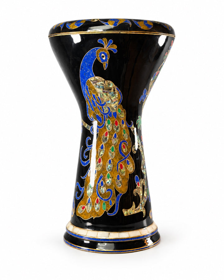 Sala Midnight Peacock Sombaty darbuka stående oppreist, og viser en blå-og-gull påfugl med fargerike haledetaljer på en mørk finish.
